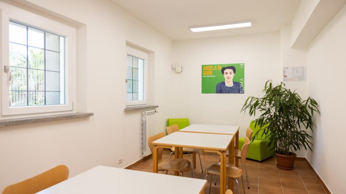 Study room with tables and side windows at Casa del Popolo
