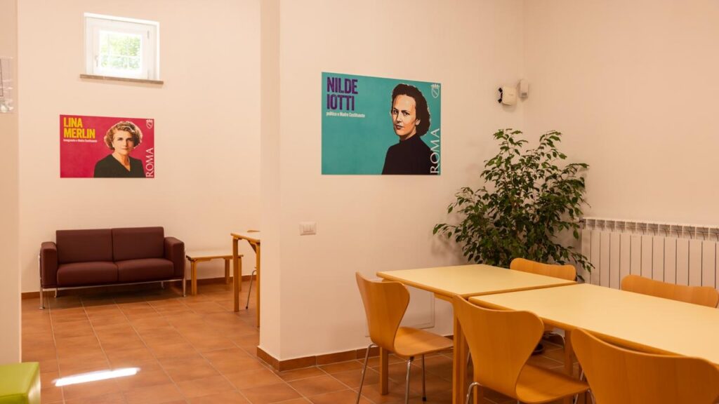 Area relax con divano e poster in aula studio Casa del Popolo