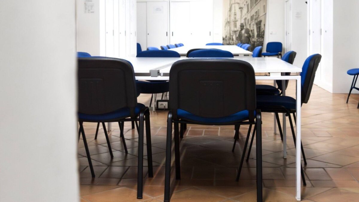 Aula studio con tavoli bianchi e sedie blu al Museo di Roma